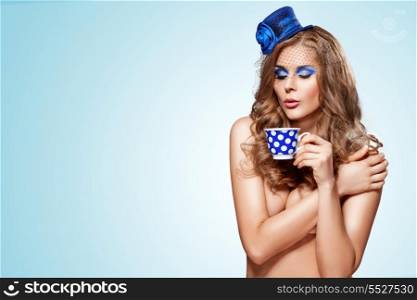 Vintage photo of cute pin-up girl in retro hat drinking tea.