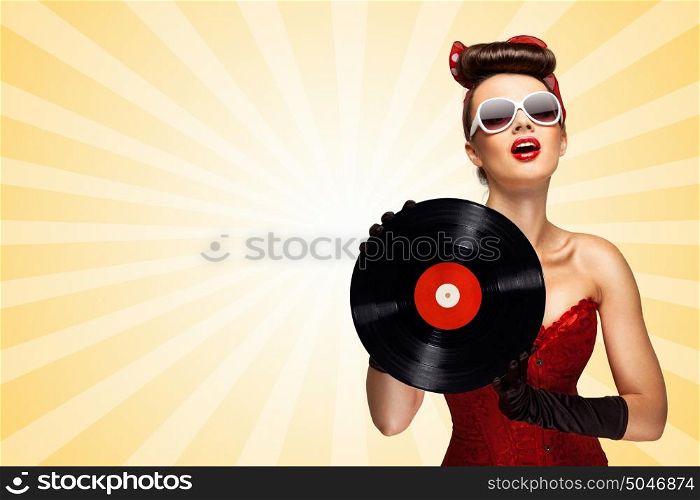 Vintage photo of glamorous pinup girl wearing long gloves and dressed in a red sexy corset, holding LP vinyl record on colorful abstract cartoon style background.