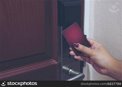 Vintage photo of lady using key card opening door in hotel room