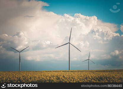 Vintage photo of wind power station at the yellow field