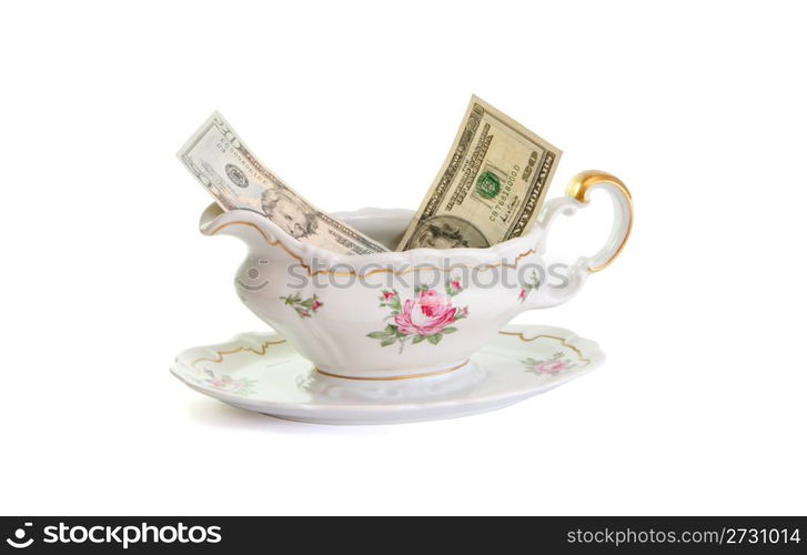 Vintage porcelain sauce-boat with dollar bills isolated