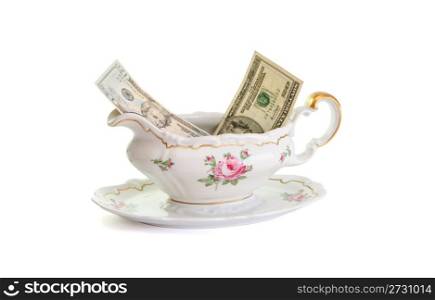 Vintage porcelain sauce-boat with dollar bills isolated