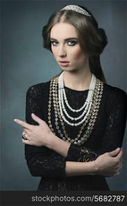 vintage portrait of beautiful brunette woman posing like a antique dame with precious crown and necklaces, retro hair-style