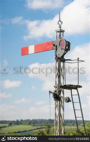 vintage railroad semaphore signal against blue sky