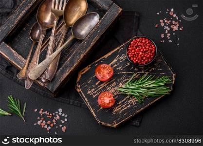 Vintage rectangular shabby wooden box with spoons and forks on a dark concrete background