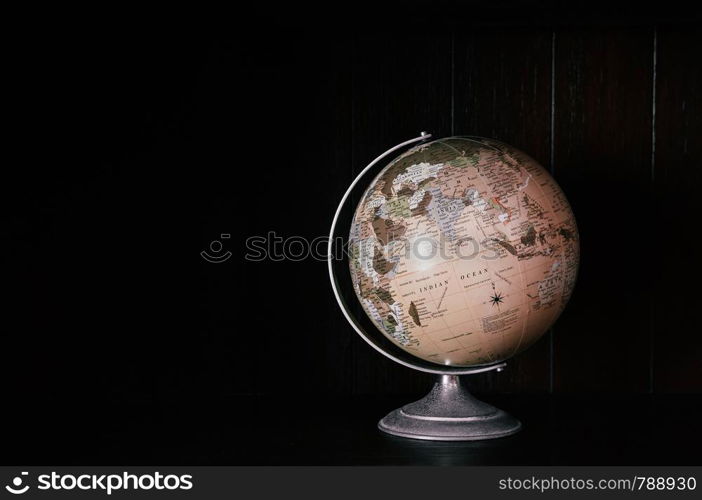 Vintage retro classic school globe model of Earth. Icon of globe. Sphere map of continents and oceans on world model on black dark back ground