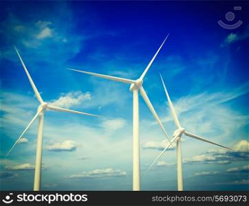 Vintage retro effect filtered hipster style image of green renewable energy concept - wind generator turbines in sky