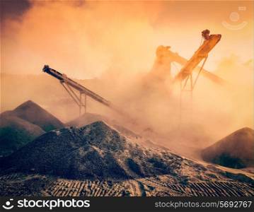Vintage retro effect filtered hipster style image of Industrial hell pollution concept - crusher rock stone crushing machine at open pit mining and processing plant for crushed stone sand and gravel
