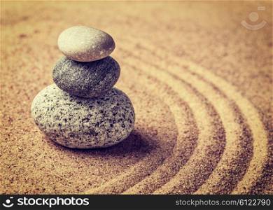 Vintage retro effect filtered hipster style image of Japanese Zen stone garden - relaxation, meditation, simplicity and balance concept - pebbles and raked sand tranquil calm scene