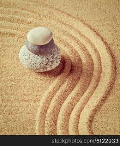 Vintage retro effect filtered hipster style image of Japanese Zen stone garden - relaxation, meditation, simplicity and balance concept - pebbles and raked sand tranquil calm scene