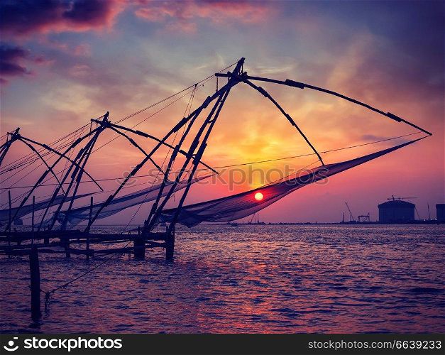 Vintage retro effect filtered hipster style image of Kochi chinese fishnets on sunset. Fort Kochin, Kochi, Kerala, India. Chinese fishnets on sunset. Kochi, Kerala, India