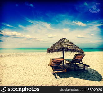 Vintage retro effect filtered hipster style image of two beach lounge chairs under tent on beach. Sihanoukville, Cambodia