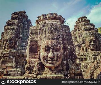 Vintage retro effect filtered hipster style travel image of ancient stone faces of Bayon temple, Angkor, Cambodia