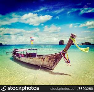 Vintage retro effect filtered hipster style travel image of long tail boat on tropical beach, Krabi, Thailand