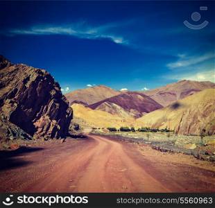 Vintage retro effect filtered hipster style travel image of Travel forward concept background - road Himalayas with mountains. Manali-Leh road, Ladakh, Jammu and Kashmir, India