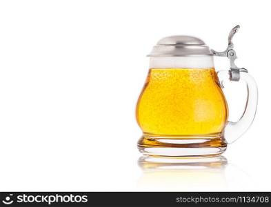 Vintage retro glass of lager ale beer with foam. Glass handle with silver steel top on white background