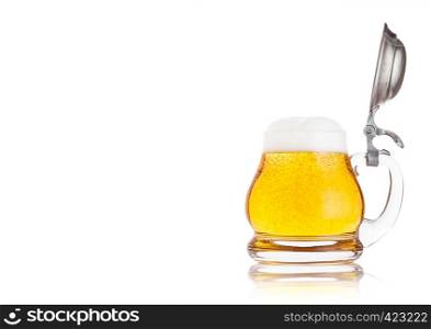 Vintage retro glass of lager ale beer with foam. Glass handle with silver steel top on white background