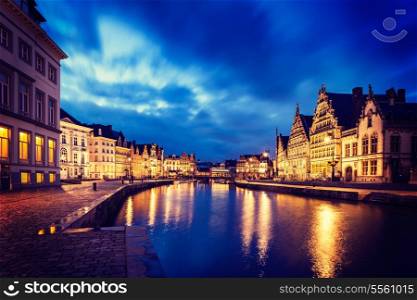 Vintage retro hipster style image of travel Europe Belgium background - Ghent canal, Graslei and Korenlei streets in twlight the evening. Ghent, Belgium
