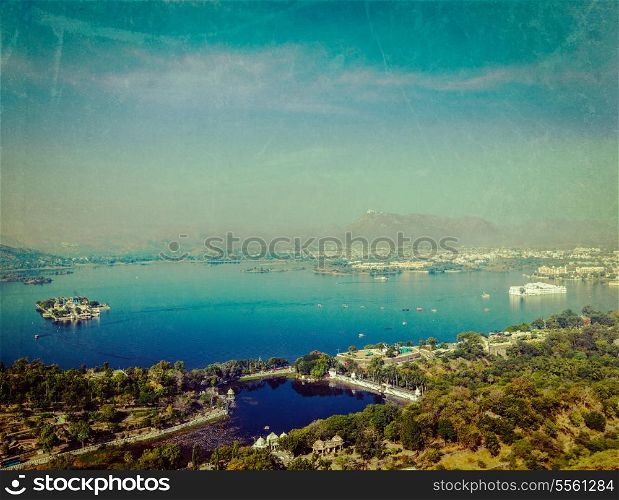 Vintage retro hipster style travel image of aerial view of Lake Pichola with Lake Palace (Jag Niwas) and Jag Mandir (Lake Garden Palace) with grunge texture overlaid. Udaipur, Rajasthan, India