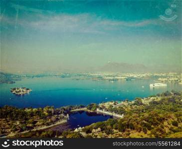 Vintage retro hipster style travel image of aerial view of Lake Pichola with Lake Palace (Jag Niwas) and Jag Mandir (Lake Garden Palace) with grunge texture overlaid. Udaipur, Rajasthan, India