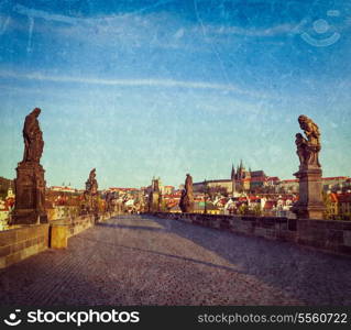 Vintage retro hipster style travel image of Charles bridge and Prague castle in the early morning with grunge texture overlaid. Prague, Czech Republic