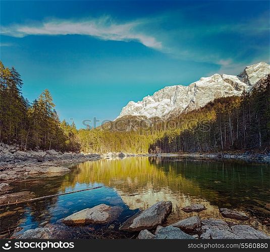 Vintage retro hipster style travel image of Frillensee (small lake near Eibsee) and Zugspitze - the highest mountain in Germany