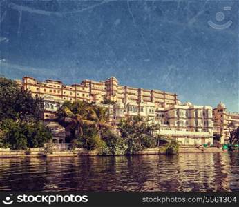 Vintage retro hipster style travel image of India luxury tourism concept background - Udaipur City Palace from Lake Pichola with grunge texture overlaid. Udaipur, Rajasthan, India