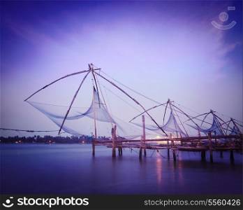 Vintage retro hipster style travel image of Kochi chinese fishnets on sunset. Fort Kochin, Kochi, Kerala, India