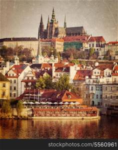 Vintage retro hipster style travel image of Mala Strana and Prague castle over Vltava river with grunge texture overlaid. Prague, Czech Republic