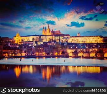 Vintage retro hipster style travel image of Prague Europe concept background - view of Charles Bridge and Prague Castle in twilight. Prague, Czech Republic