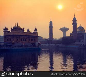 Vintage retro hipster style travel image of Sikh gurdwara Golden Temple (Harmandir Sahib) on sunrise. Amritsar, Punjab, India