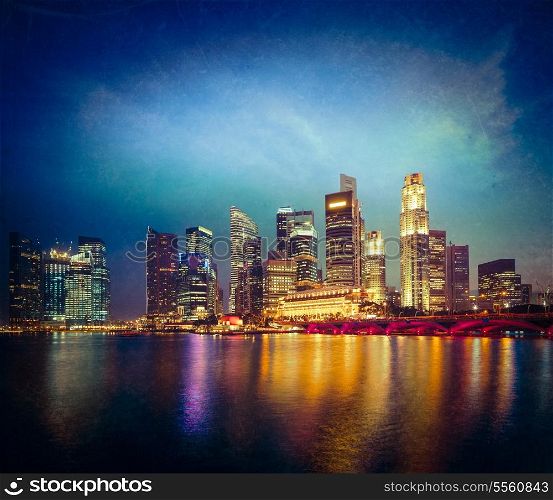 Vintage retro hipster style travel image of Singapore skyline and Marina Bay in evening