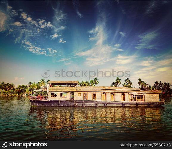 Vintage retro hipster style travel image of travel tourism Kerala background - houseboat on Kerala backwaters. Kerala, India