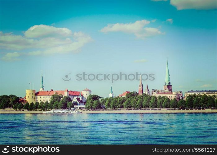 Vintage retro hipster style travel image of View of Riga over Daugava river: Riga Castle, St. James&rsquo;s Cathedral, St. Peter&rsquo;s Church. Riga, Latvia