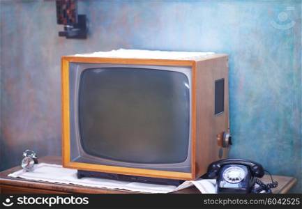 Vintage retro look living room detail. Television, telephone and clock on wooden old table