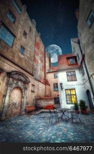 Vintage retro travel image of a narrow medieval street in old town Riga. night shining moon and stars