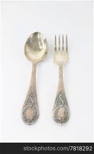 Vintage silver fork and spoon with ornaments on white background