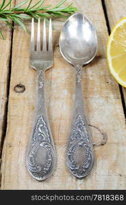 Vintage silver fork and spoon with ornaments on wooden background