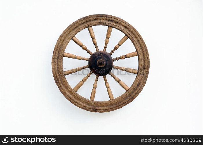 Vintage spinning wheel against the shabby white wall background