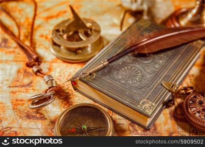 Vintage still life - magnifying glass, pocket watch, old book and goose quill pen lying on an old map in 1565.