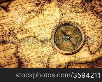 Vintage still life. Vintage compass lies on an ancient world map.