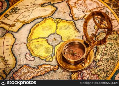 Vintage still life. Vintage compass lies on on the ancient map of the North Pole (also Hyperborea).. Arctic continent on the Gerardus Mercator map of 1595.