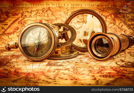 Vintage still life. Vintage magnifying glass and compass lies on an ancient world map in 1565.