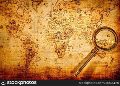 Vintage still life. Vintage magnifying glass lies on an ancient world map