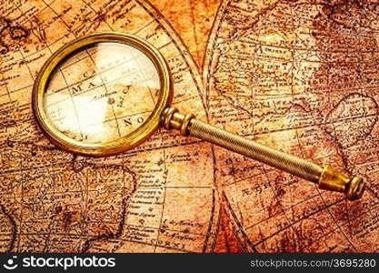 Vintage still life. Vintage magnifying glass lies on an ancient world map