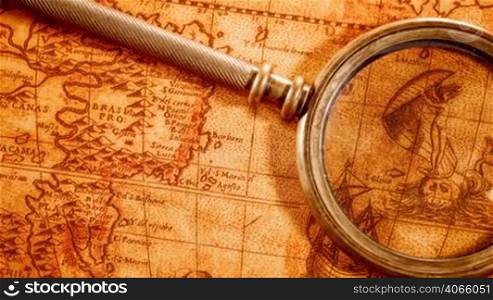 Vintage still life. Vintage magnifying glass lies on an ancient world map in 1565