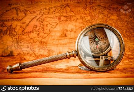 Vintage still life. Vintage magnifying glass lies on an ancient world map in 1565.