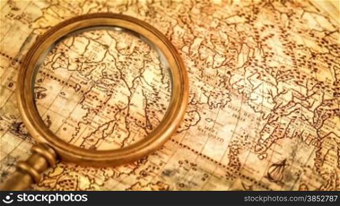Vintage still life. Vintage magnifying glass lies on ancient world map in 1565.
