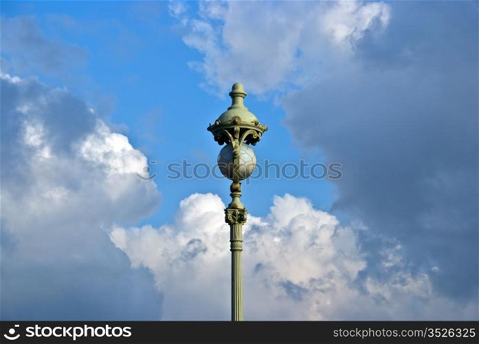 vintage street lamp with glass sphere on cloud sky background