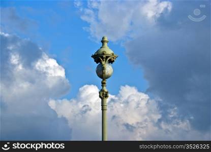 vintage street lamp with glass sphere on cloud sky background